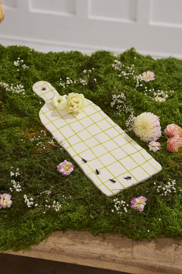Decorative cutting board with flowers on a bed of moss
