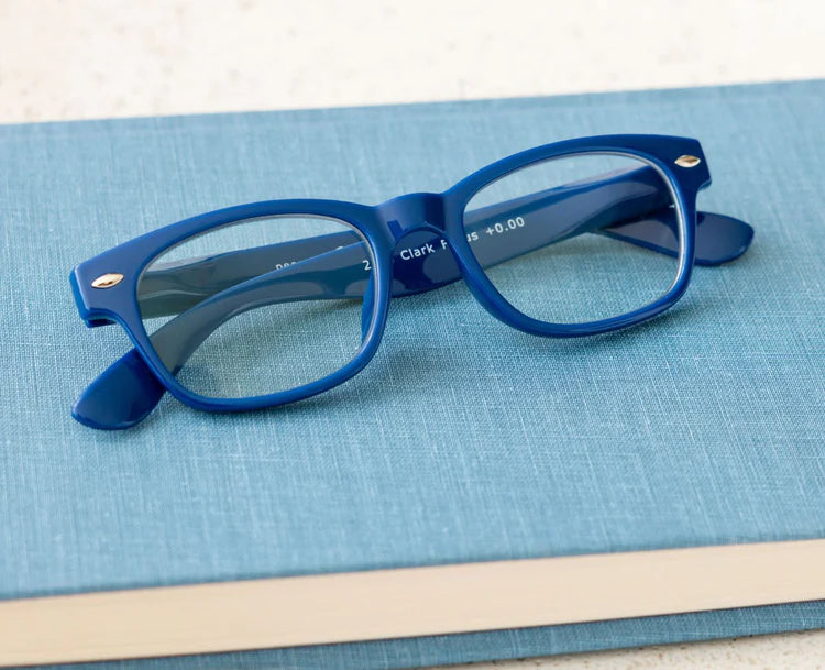 Blue reading glasses on a blue surface