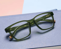 Green eyeglasses on a light blue surface
