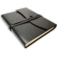 Black leather notebook with a strap closure on a white background