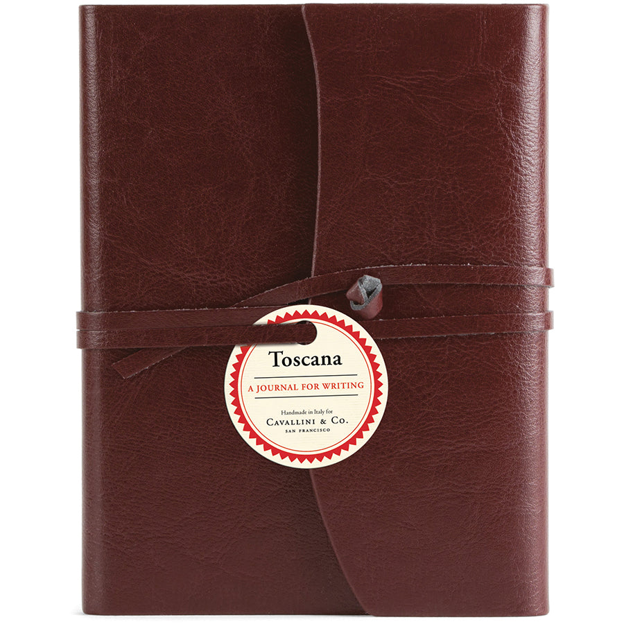 Dark red leather journal with a label on a white background