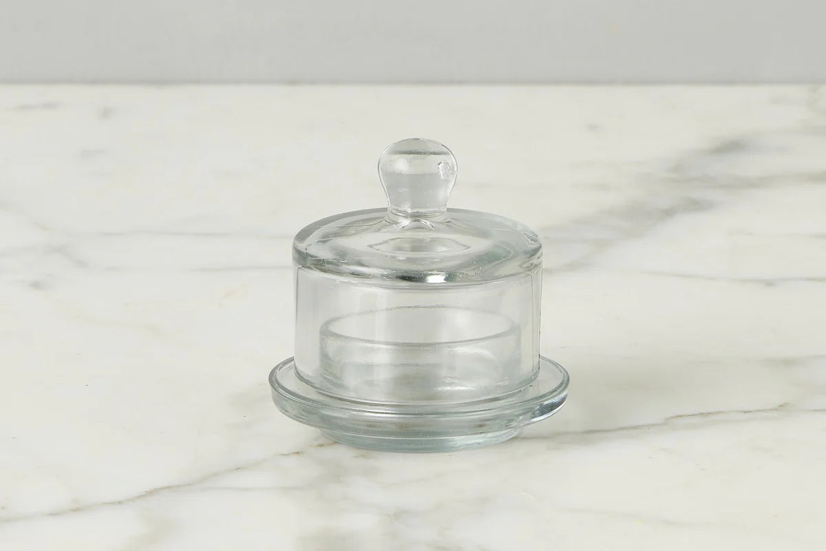 Clear glass jam jar with lid on a marble surface