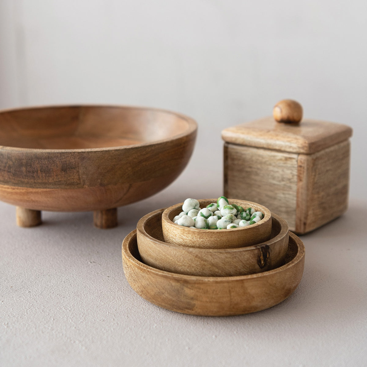 Set of wooden bowls and a container on a light background