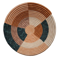 Round woven basket with concentric circle pattern on a white surface