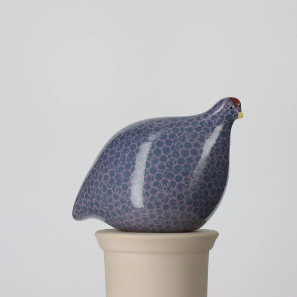 Ceramic quail figurine with a spotted pattern on a white background
