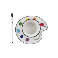Ceramic cup with saucer featuring color swatches and a paintbrush on a white background