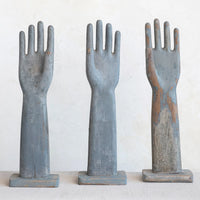 Three rustic wooden hand-shaped figures on a white background