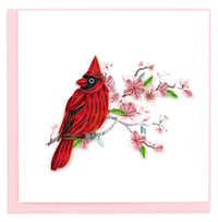 Quilled red cardinal bird on a branch with pink flowers on a greeting card with a pink envelope on a white background.