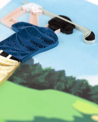 Close up of a quilled golfer design on a greeting card.