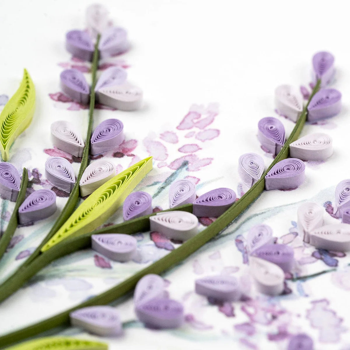 Quilled paper lavender flowers and leaves on a white background