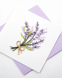 Greeting card with lavender design and gold bow on a white background