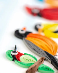 Colorful paper quilled bird figures on a white background