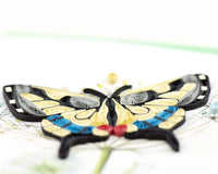 Close up of a quilled swallowtail butterfly greeting card on a white background.