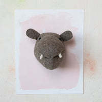 Hippo-shaped decorative head on a pink and white background