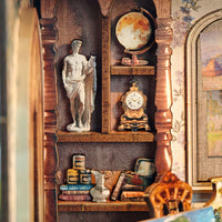 A miniature vintage-style decorative wooden shelf with arched recesses, holding a white classical statue, a globe, an ornate clock, books, and small decorative objects in a warm antique room setting.