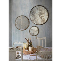 Dining room with round mirrors on the wall and a table set for a meal.