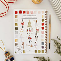 Artistic coloring book with watercolor illustrations on a white surface with decorative items.