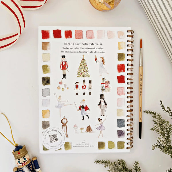 Artistic coloring book with watercolor illustrations on a white surface with decorative items.
