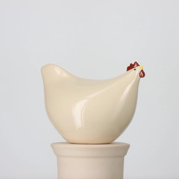 Ceramic chicken-shaped statue on a white background
