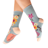 Floral-patterned socks worn by a person on a white background