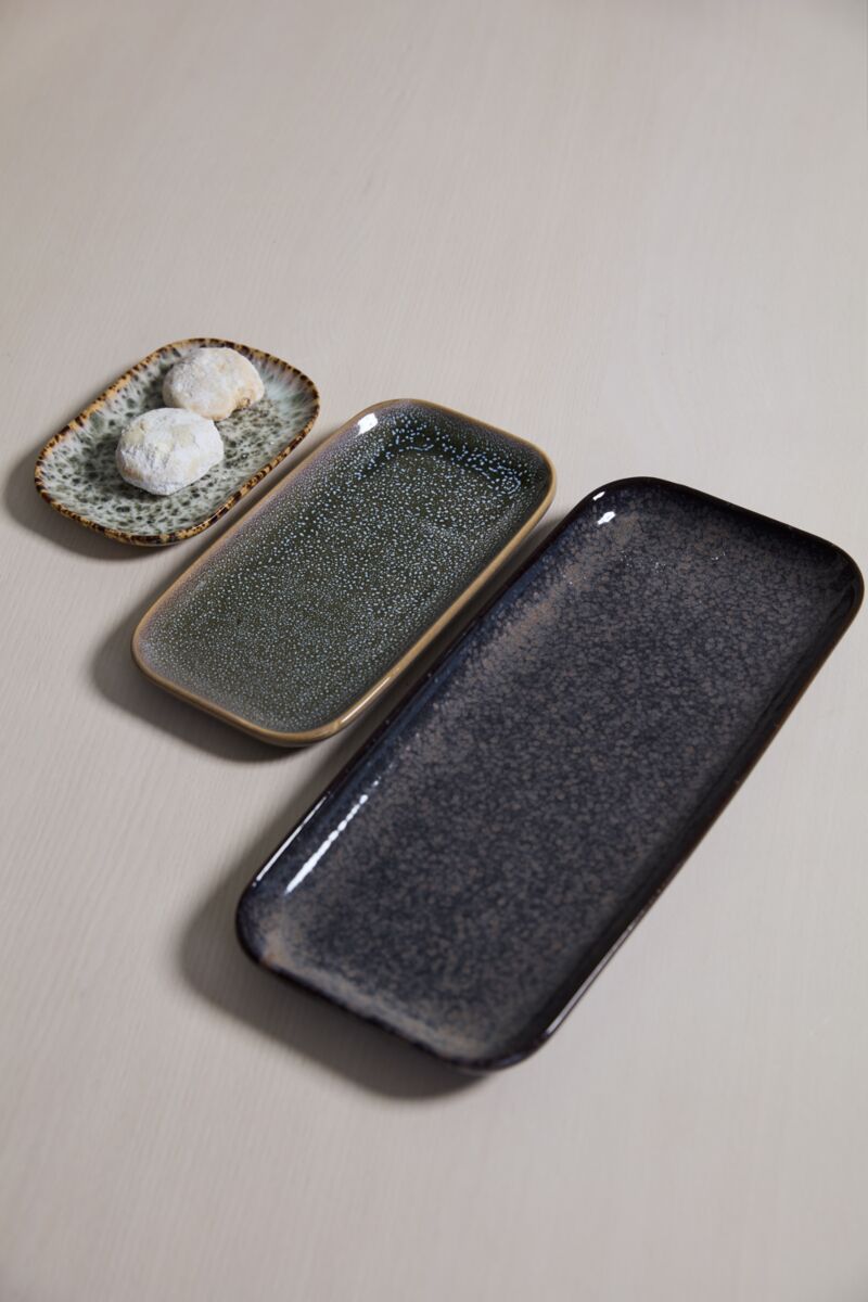 Set of three speckled ceramic trays on a neutral background