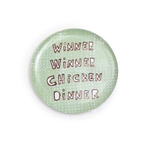 A round plate with a light green speckled pattern and the phrase 'WINNER WINNER CHICKEN DINNER' written in a brown, hand-drawn font, set against a plain white background.