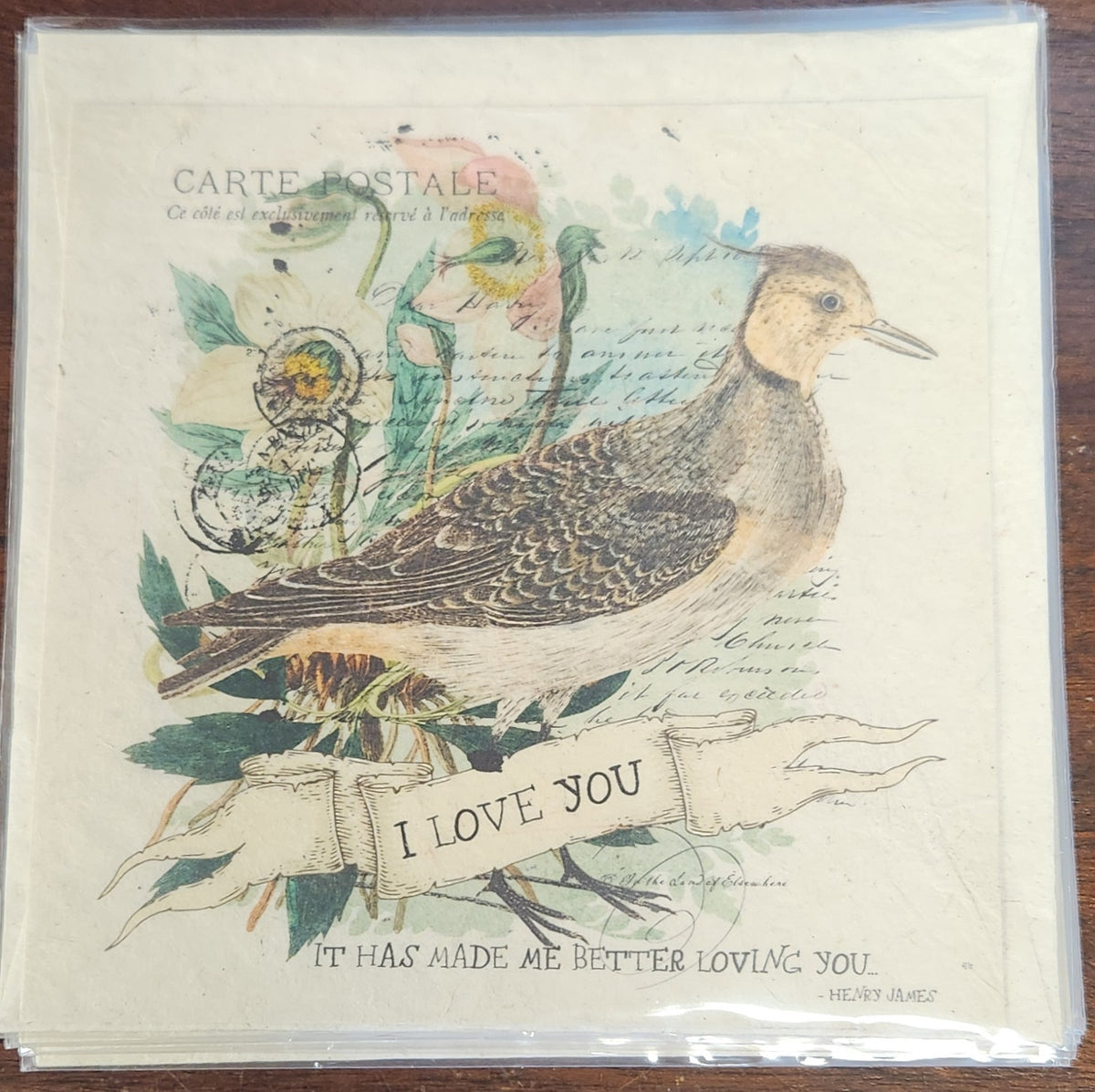 Greeting card with a bird illustration and 'I love you' text on a wooden surface