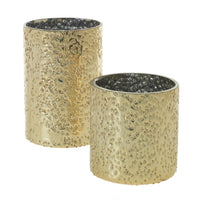 Two cylindrical glass votive holders with a dimpled gold finish, intended for use as home decor.